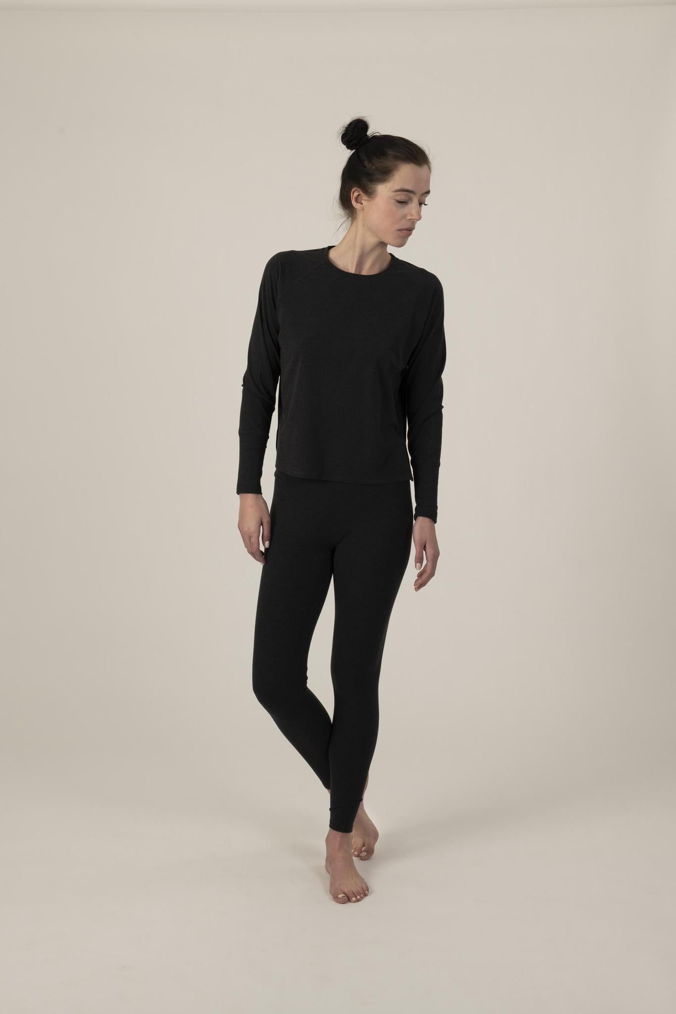Model wearing graphite relaxed-fit cozy top with round neckline and dropped shoulders, with matching leggings