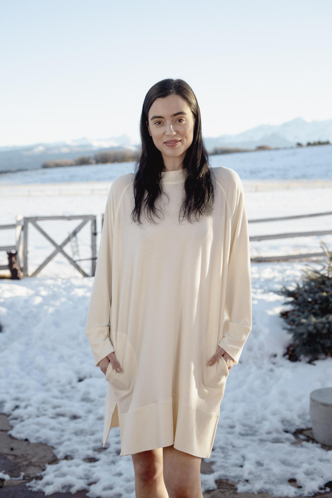 Model wearing Cozy Dress in Cashmere with relaxed fit, round neckline, and side pockets.