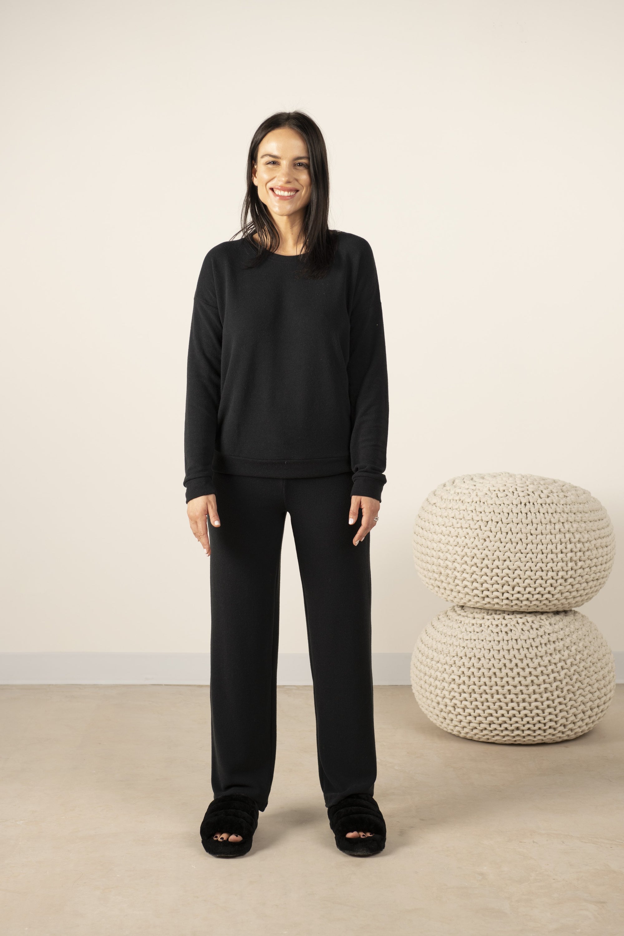 Model wearing cozy wide-leg pants in black, paired with a black long sleeve top.