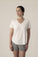 Model wearing the V-neck T-Shirt in Ivory, relaxed, semi-fitted cut with gray shorts