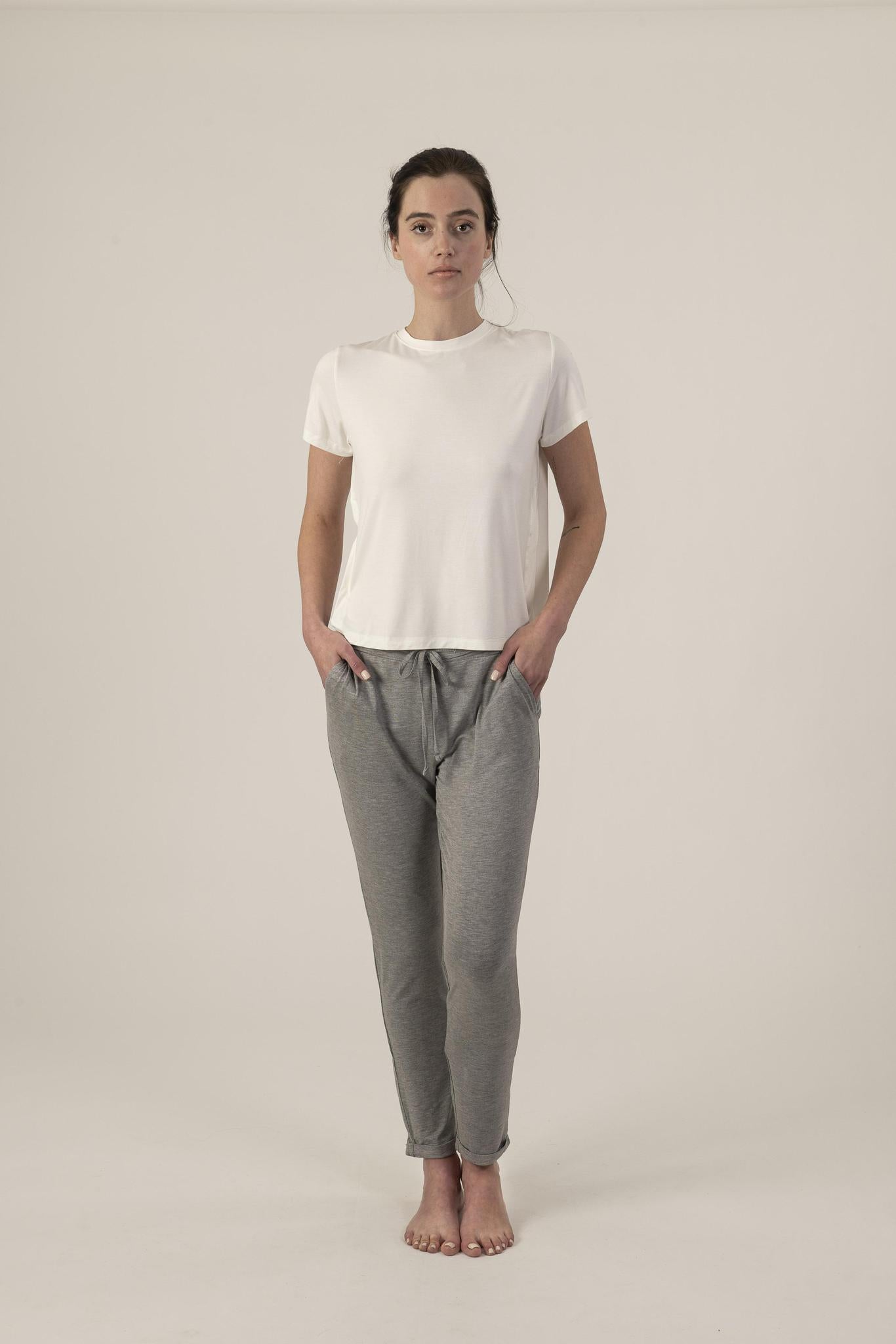 A model wearing heather gray lounge joggers with a white t-shirt, the joggers have a drawstring waist and pockets.