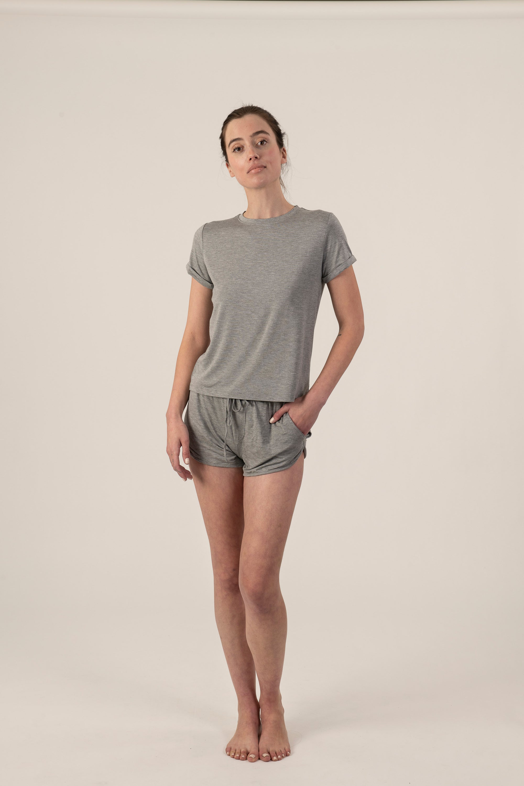 Model wearing the Taylor Rolled Sleeve T-Shirt in Gray, relaxed fit and rolled sleeves, with matching gray shorts