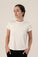 Model wearing ivory rolled sleeve T-shirt with relaxed fit and soft bamboo fabric