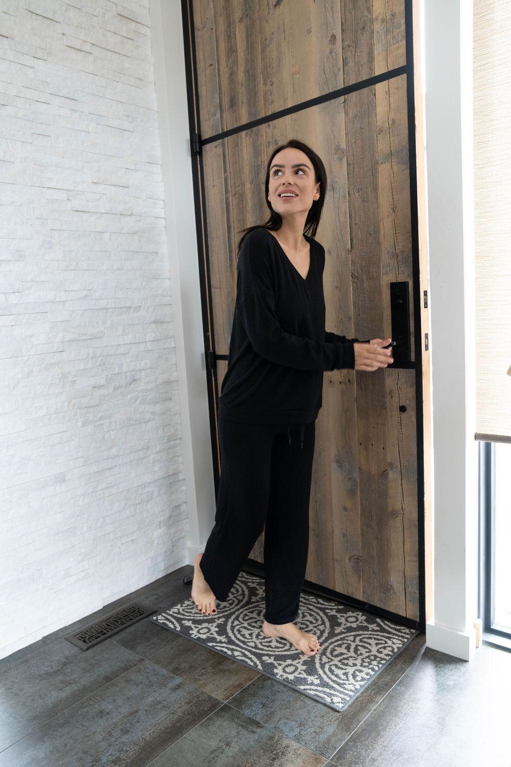 Model wearing black cozy pajama set with wide-leg pants and V-neck long sleeve top