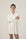 Model wearing Dahlia Chic Nightshirt in ivory with gathered neckline, long cuffs, and mother-of-pearl buttons