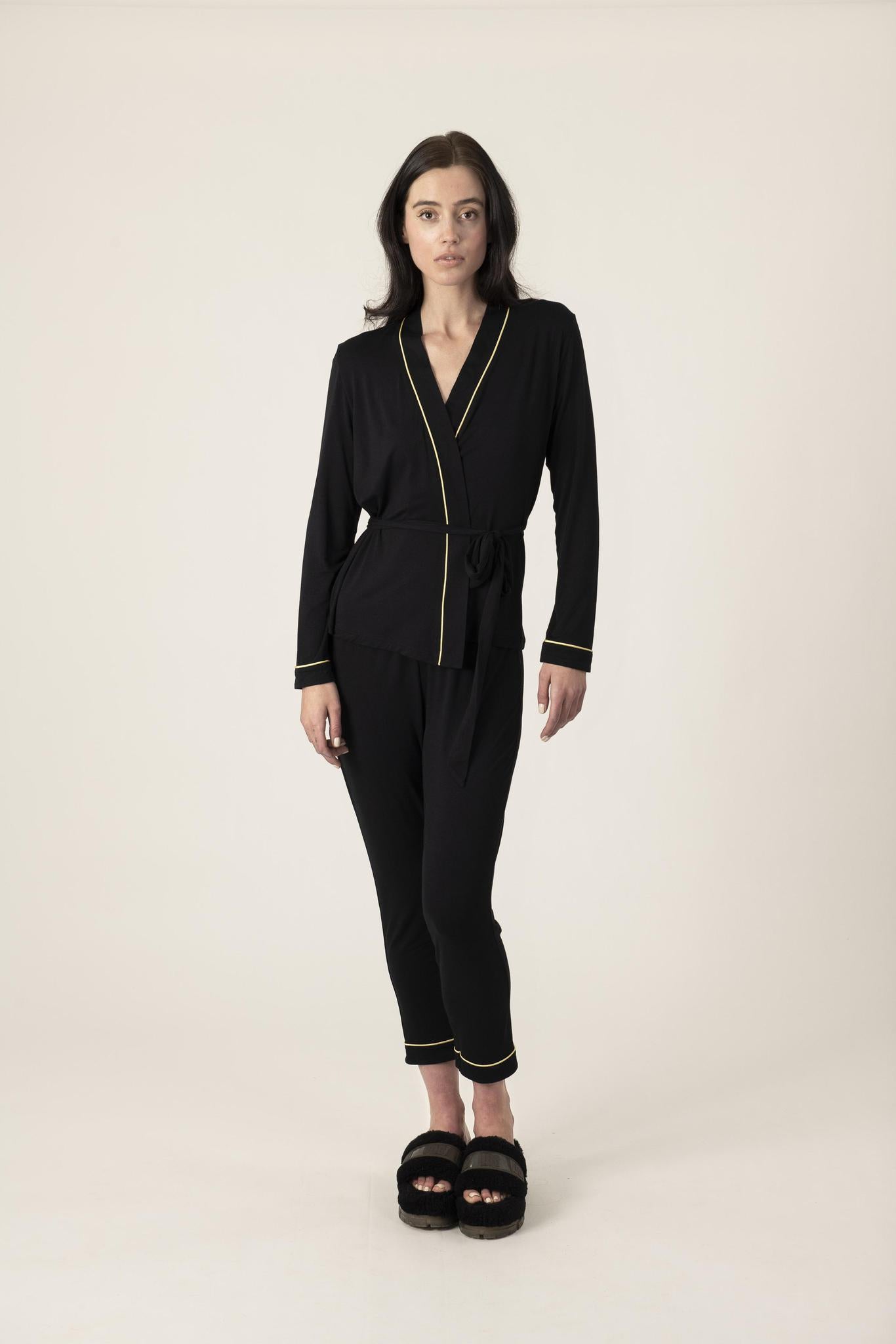 Model wearing the Grand Queenie Pajama Set in black with gold detailing and kimono-style wrap top
