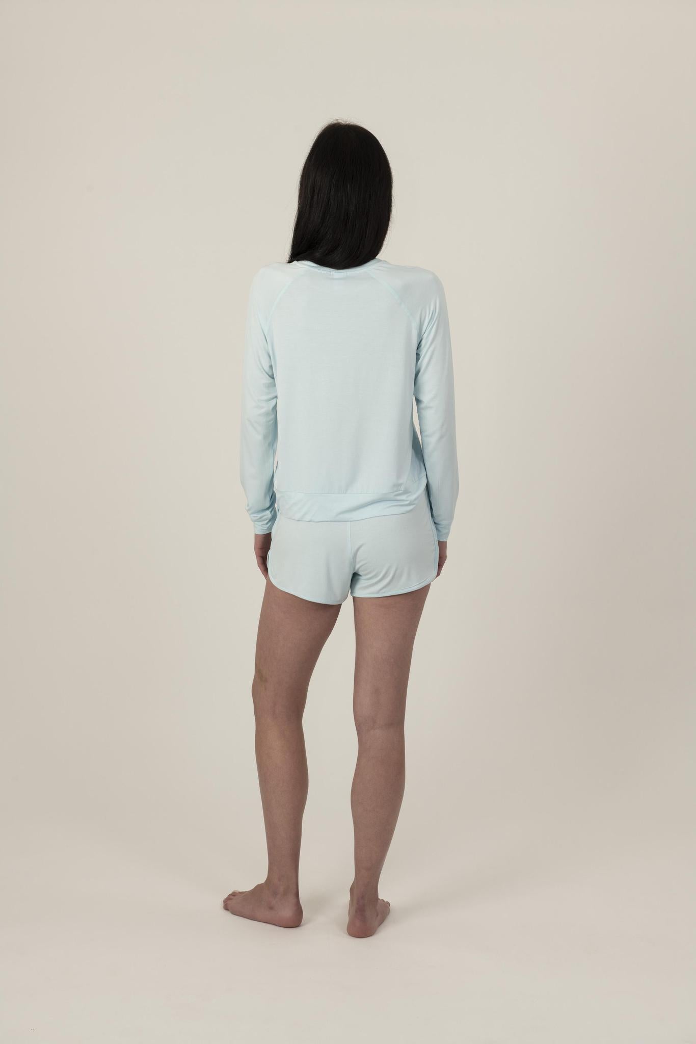 Back view of Hang Out Track Shorts in Ice Blue showing soft bamboo fabric and side pockets, with matching long sleeve top.