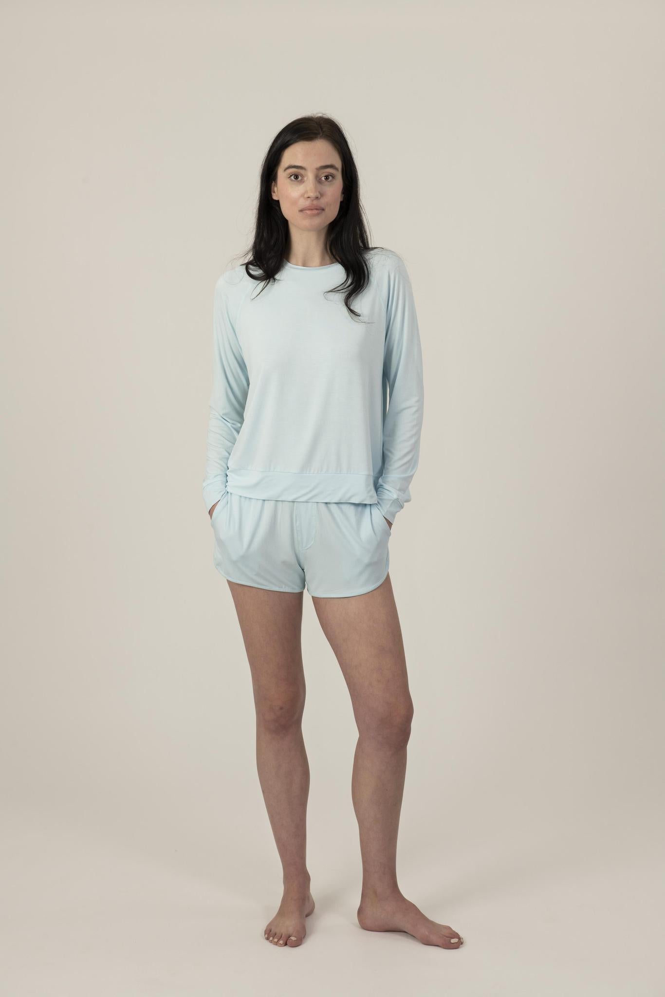 Model wearing Hang Out Track Shorts in Ice Blue with relaxed fit and drawstring waistband, with matching long sleeve top.
