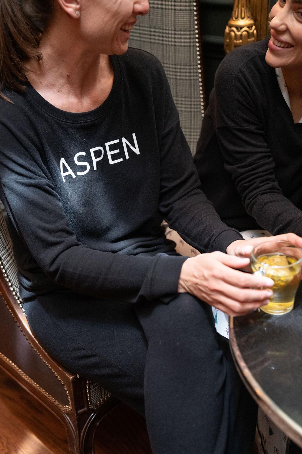 Model wearing black Hello from Aspen long sleeve top with relaxed fit and crew neckline