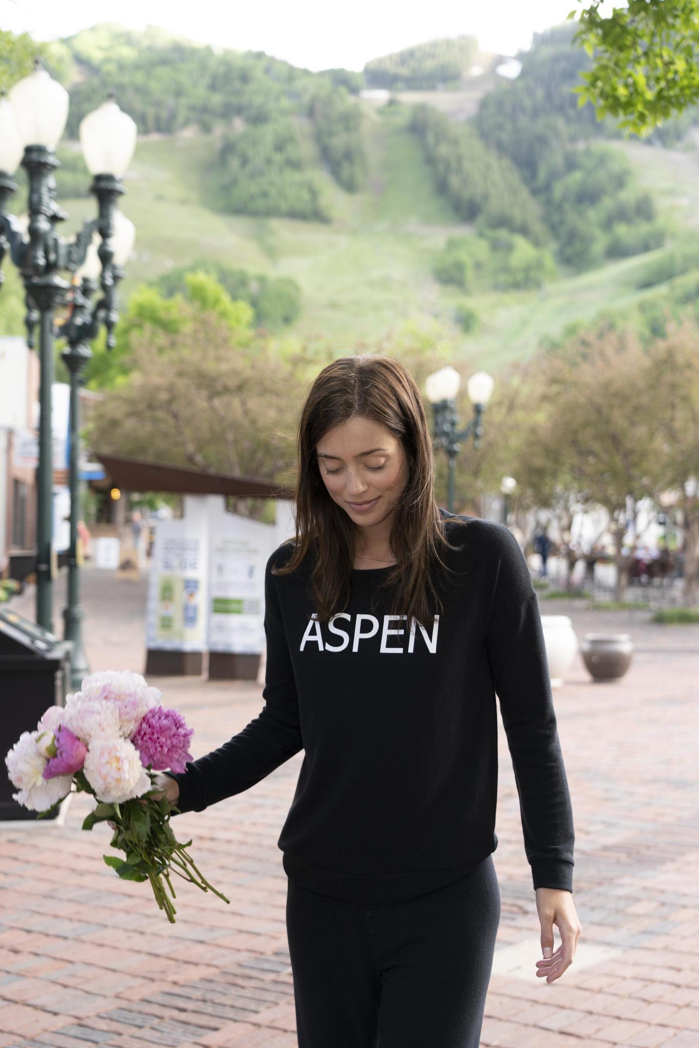 Model wearing black Hello from Aspen long sleeve top with relaxed fit and crew neckline