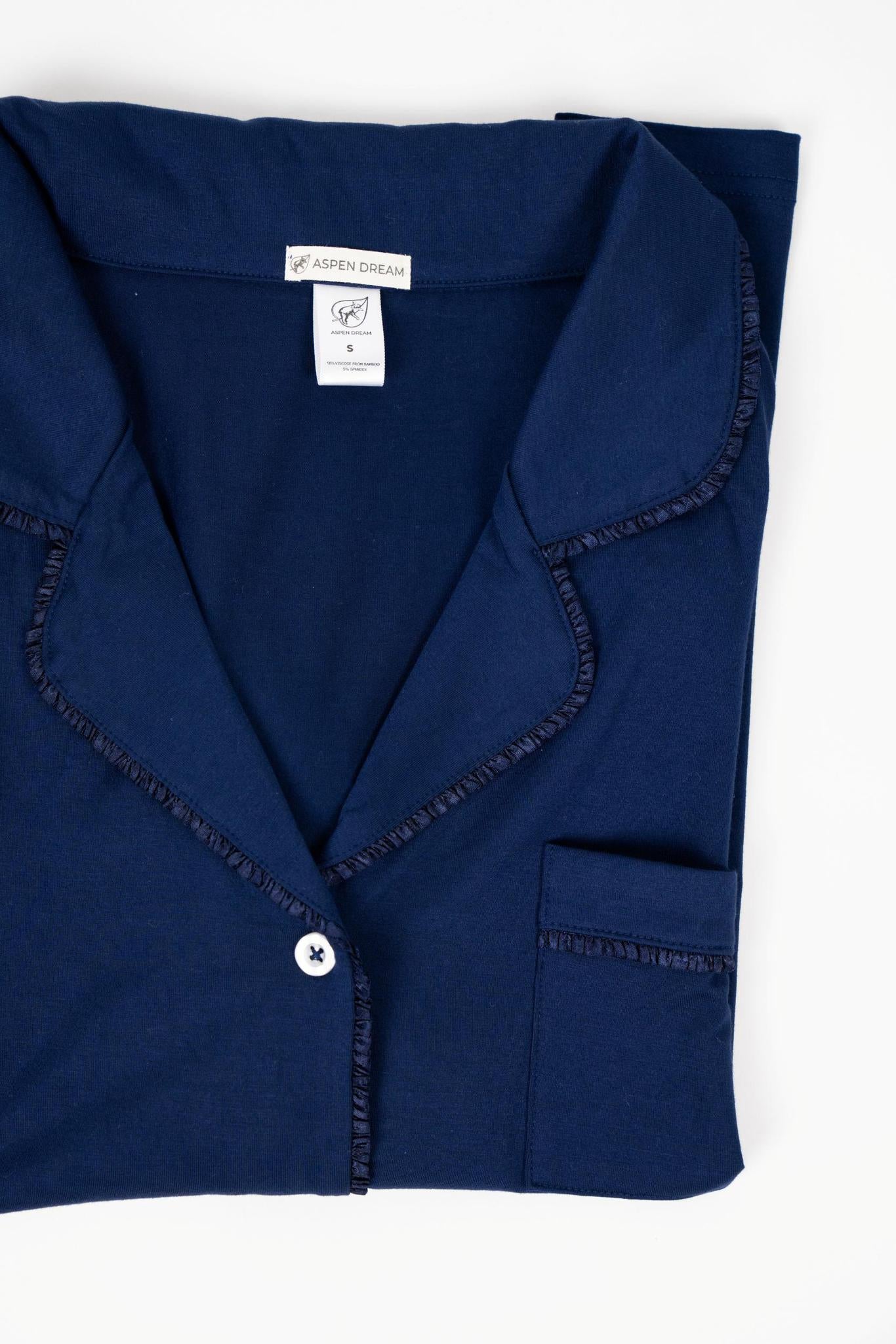 Flat lay of the Jolene Cropped Pajama Top in navy with button-down top and Japanese ruffled piping