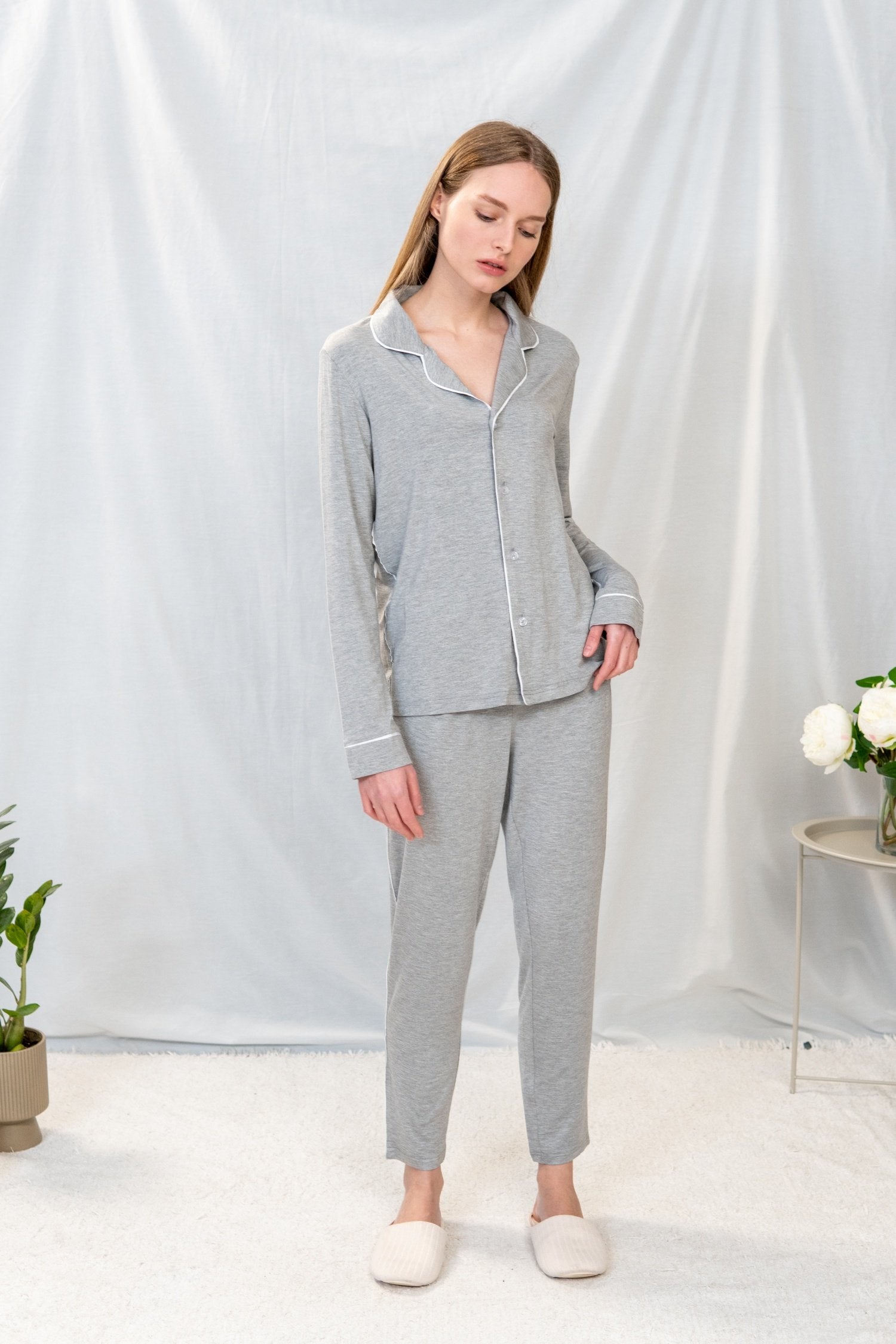 Model wearing Jolene Long Pajama Set in heather gray with white piping and tapered ankle-length pants