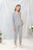 Model wearing Jolene Long Pajama Set in heather gray with white piping and tapered ankle-length pants