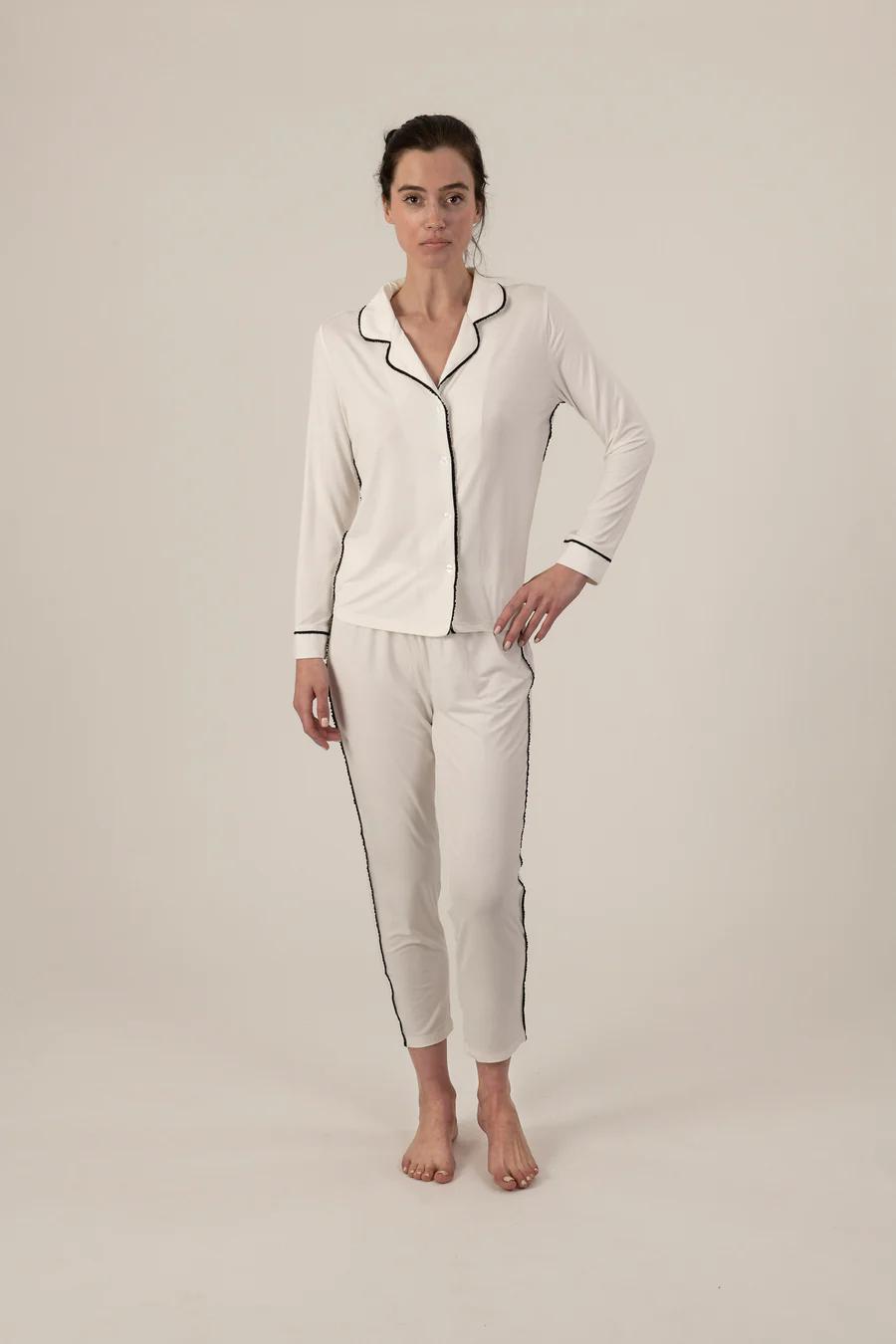 Model wearing Jolene Long Pajama Set in ivory with black piping and ankle-length tapered pants