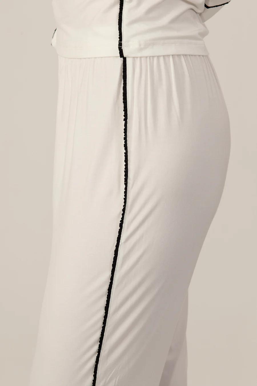 Close-up of black Japanese piping detail on the ivory Jolene pajama pants.