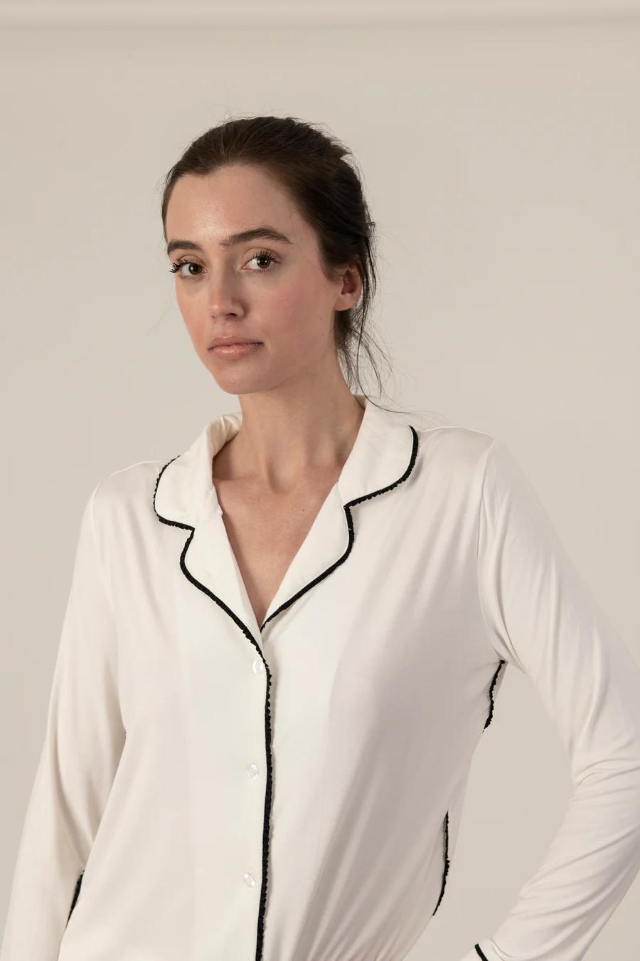 Model wearing Jolene Long Pajama Set in ivory with black piping and ankle-length tapered pants