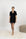 Model wearing Jolene Short Pajama Set in black with white ruffled piping and short-sleeve button-down top