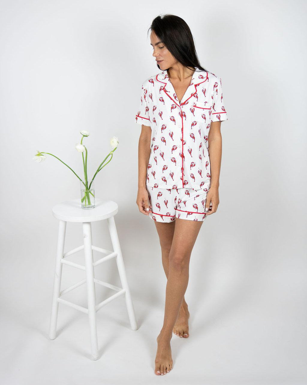 Model wearing Jolene Short Pajama Set with lobster print and red piping, featuring a button-down top and mid-rise shorts.