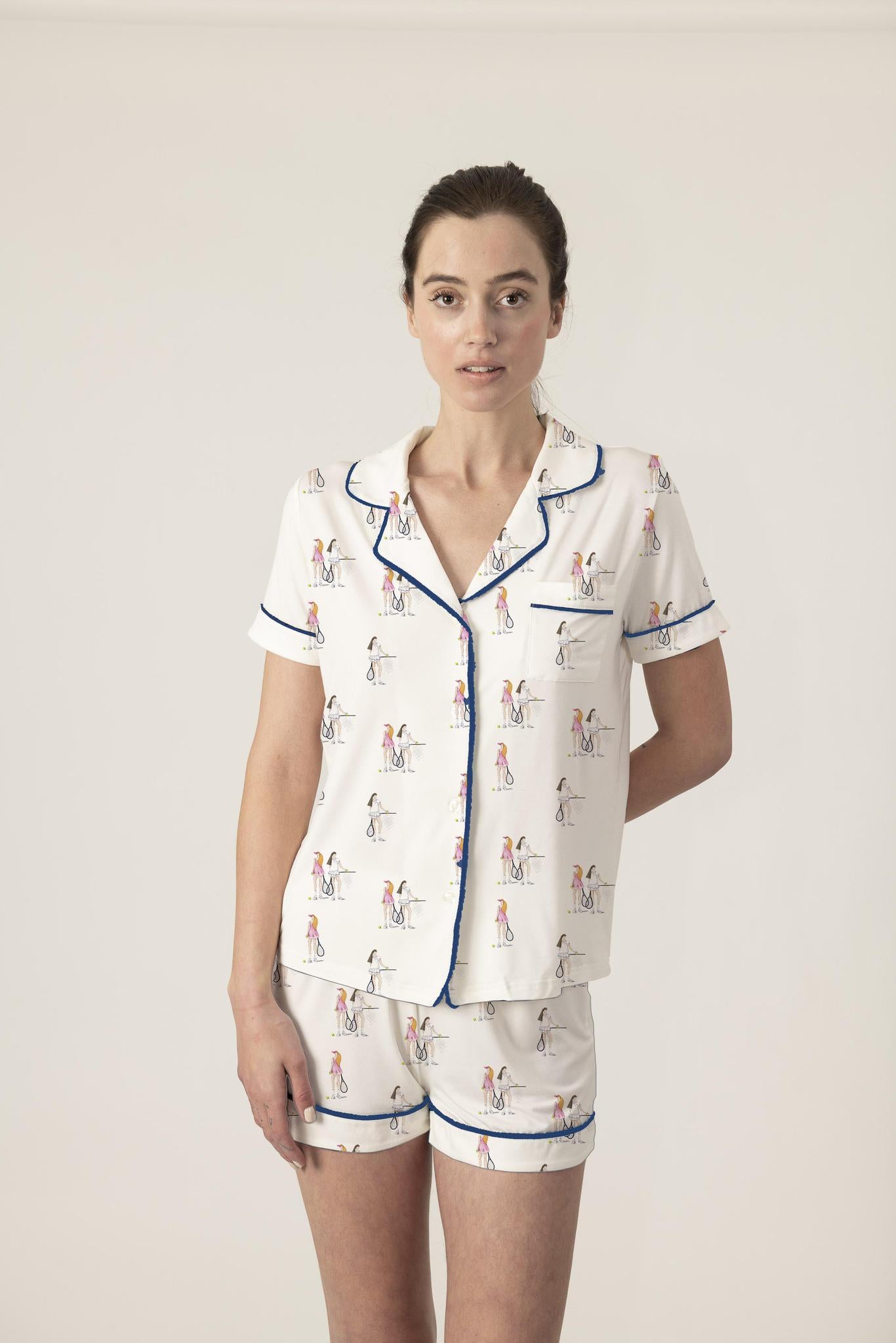 Model wearing Jolene Short Pajama Set with hand-drawn tennis print, black ruffled piping, and short-sleeve button-down top