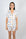 Model wearing Jolene Short Pajama Set with hand-drawn hummingbird print and orange piping on white bamboo fabric