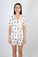 Model wearing Jolene Short Pajama Set with hand-drawn hummingbird print and orange piping on white bamboo fabric