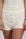 Model wearing Ribbed Shorts in Ivory with ribbed texture and golden button detail.