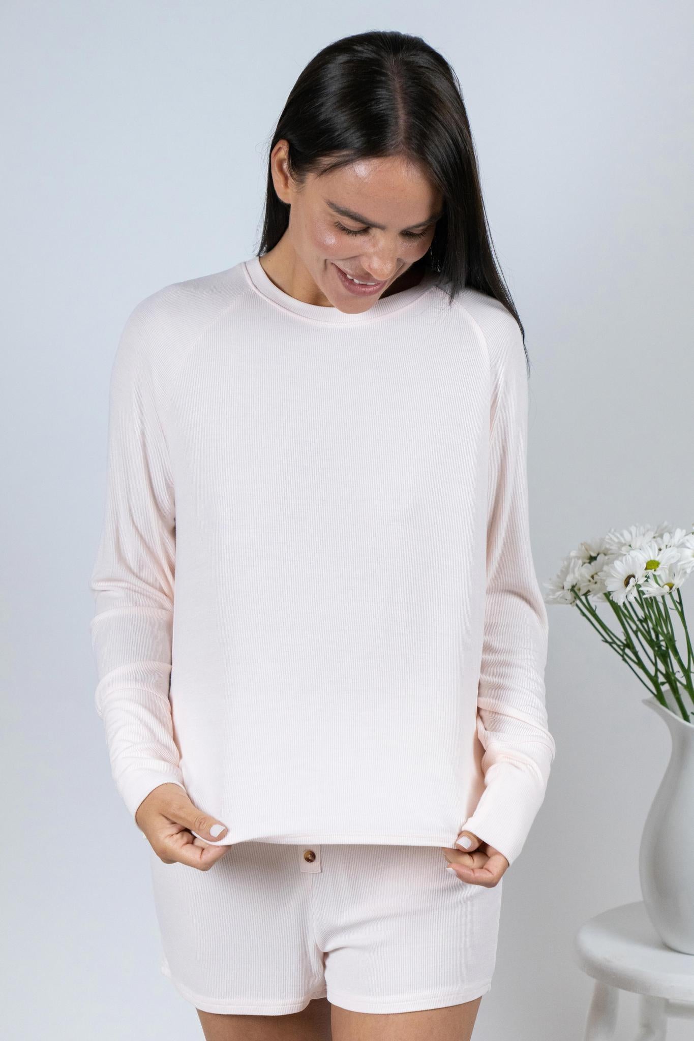 Model wearing Ribbed Shorts in Rosewater with ribbed texture and golden button detail, with matching long sleeve top