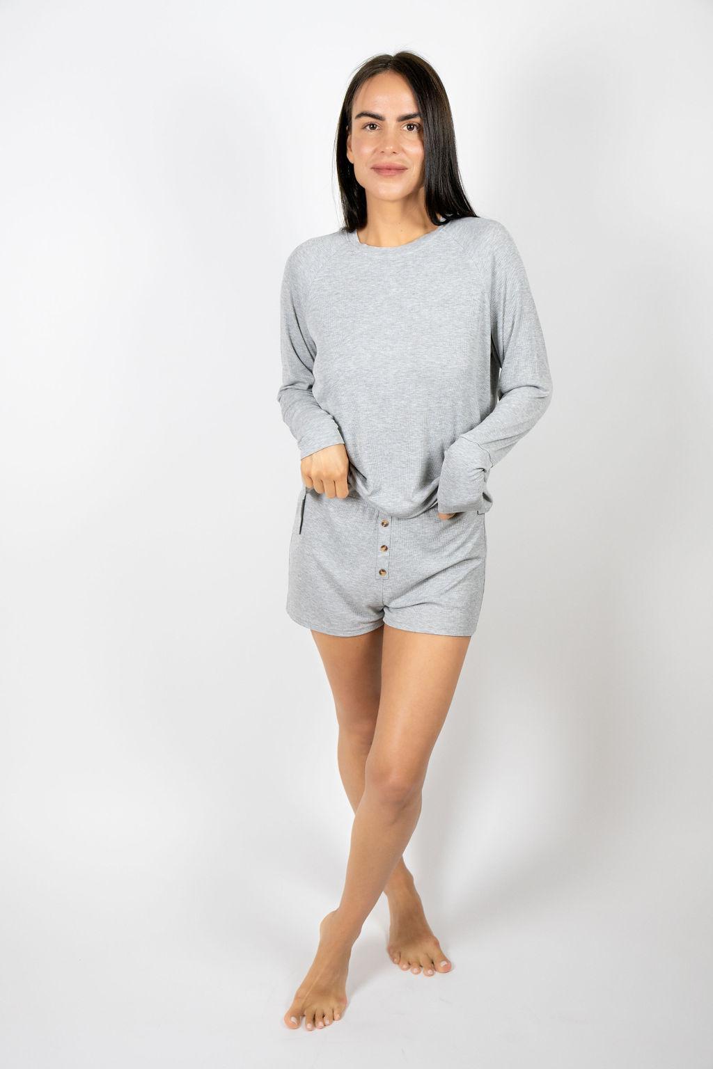 Model wearing Ribbed Shorts in Silver with ribbed texture and golden button detail, with matching long sleeve top.