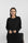 Model wearing black ribbed long sleeve top with relaxed fit and subtle side slits