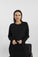 Model wearing black ribbed long sleeve top with relaxed fit and subtle side slits